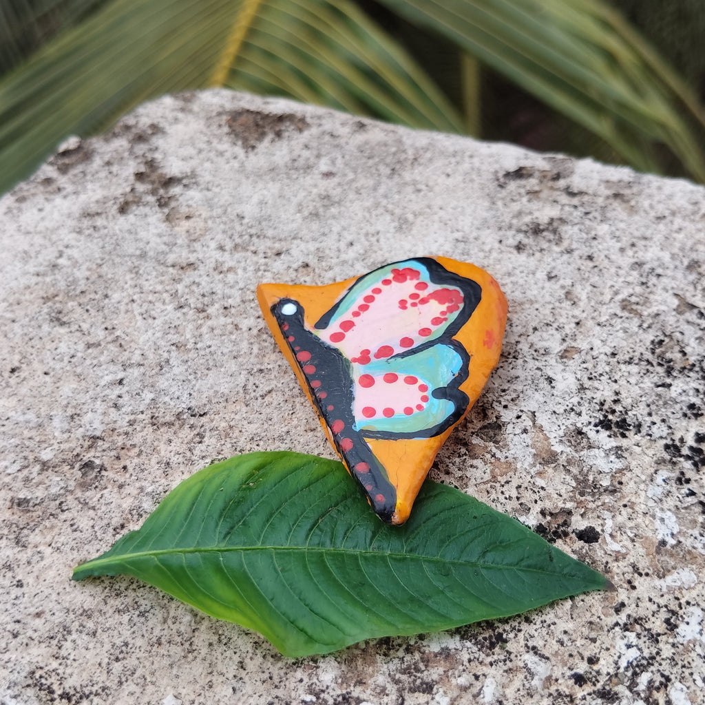 Colorful butterfly-shaped magnet on a green leaf with a natural background. - Sustainable Home Decor