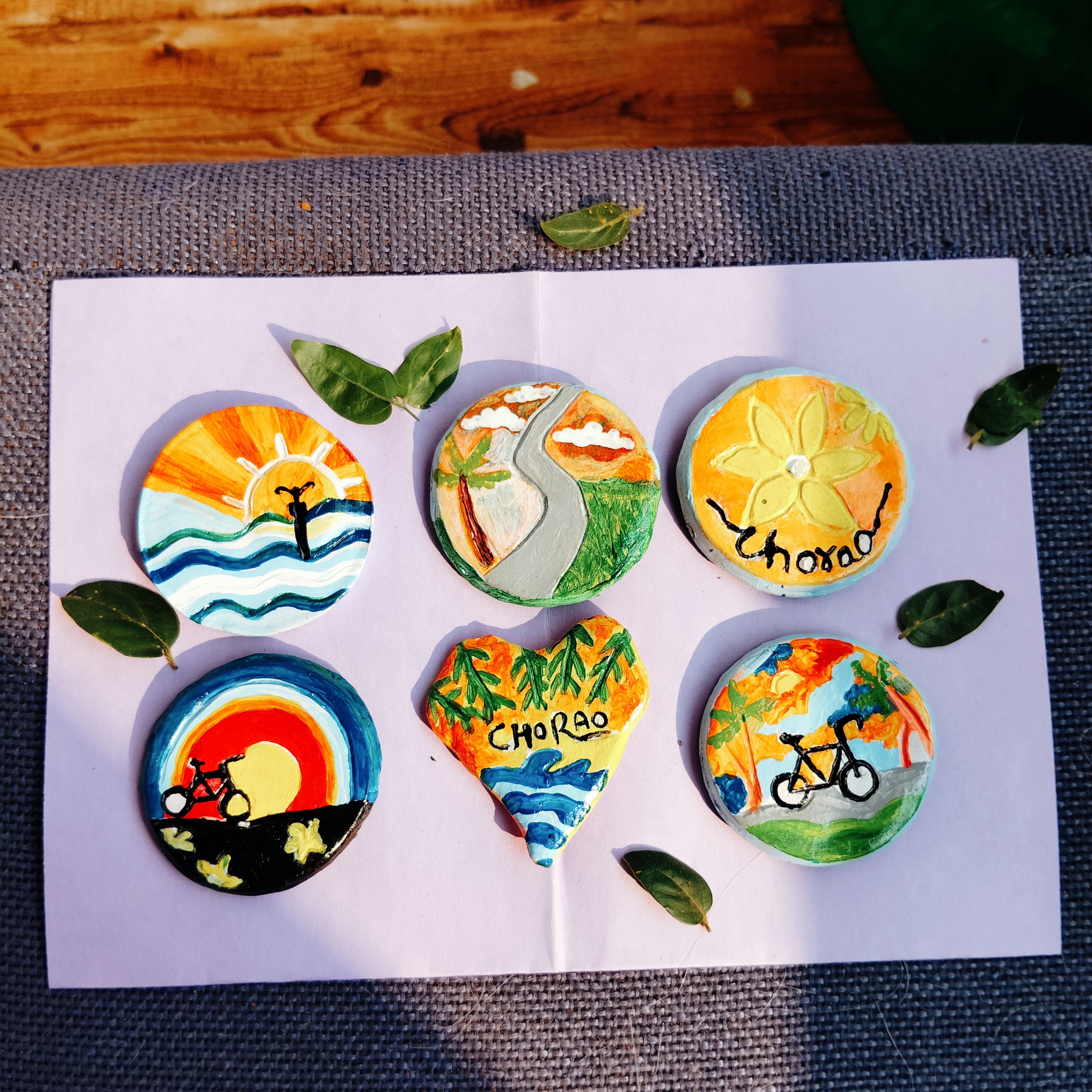 Set of colorful eco-friendly earthy magnets with artistic designs on a handcrafted clay surface, placed on a table top.