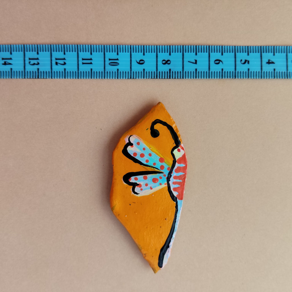 A miniature artistic magnet lying on beige background with measuring tape - Sustainable Home Decor