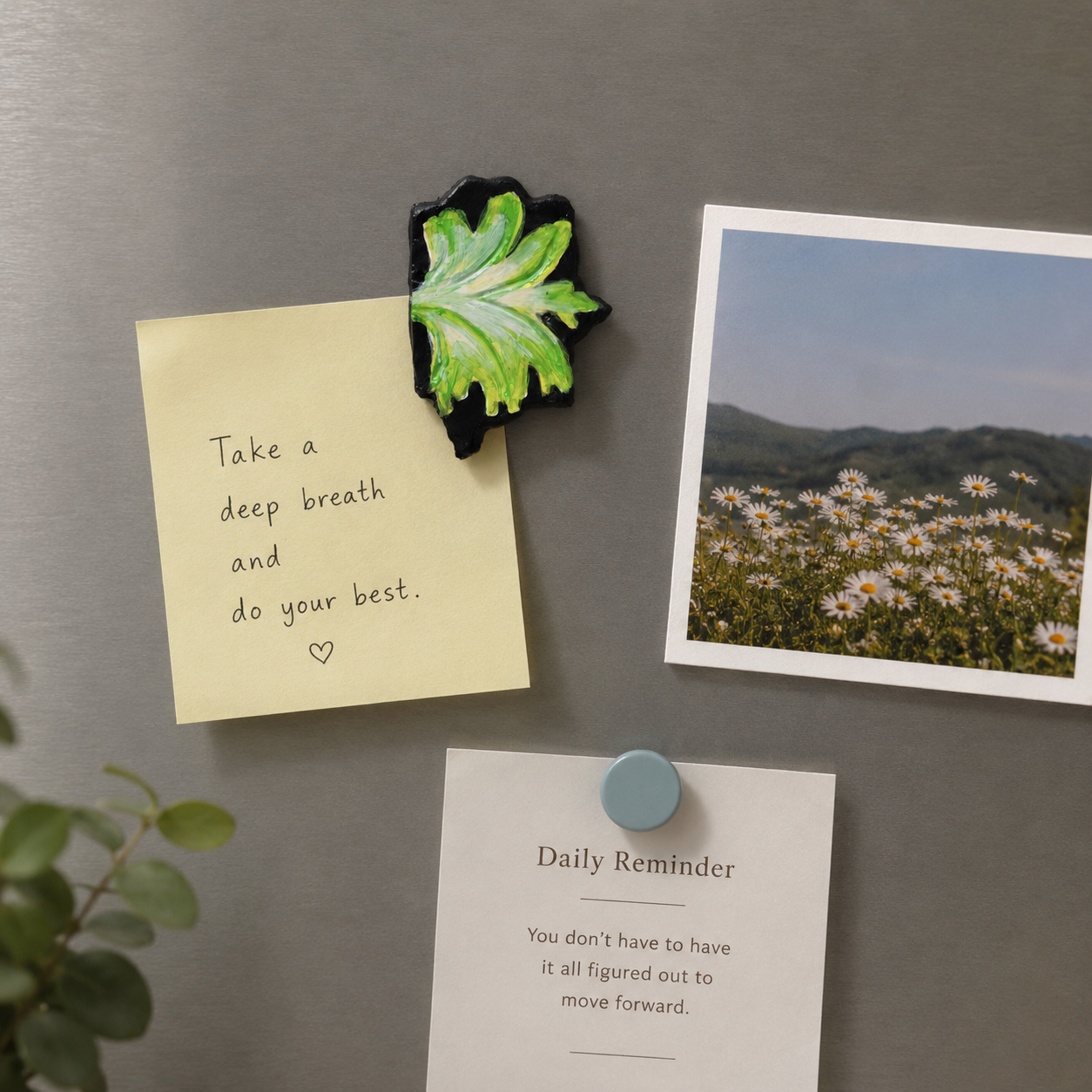 Magnet with leaf design on a refrigerator next to a motivational note and photo - Sustainable Home Decor & Upcycled Glass