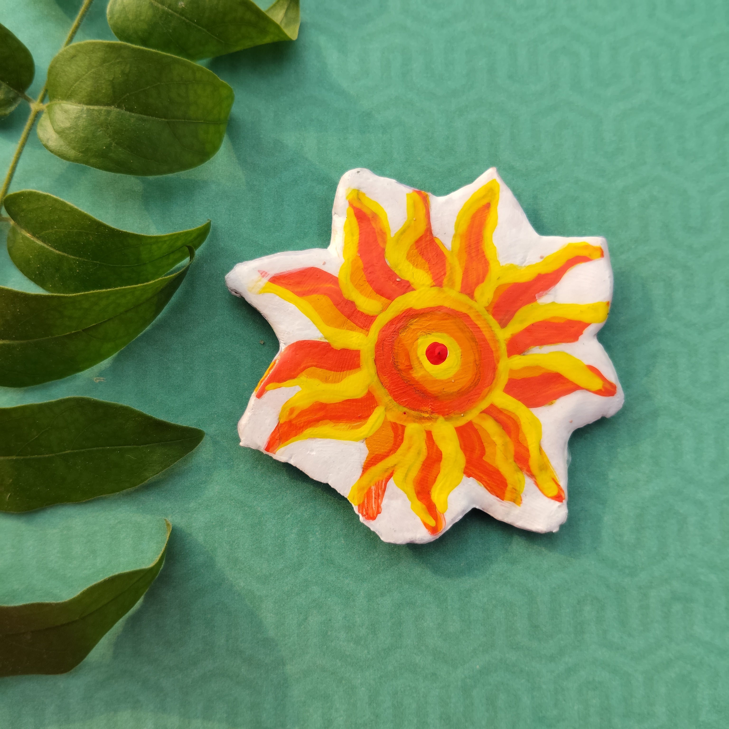 Decorative sun-shaped handmade artistic magnet with a colorful design on a green textured background - Sustainable Home Decor & Upcycled Glass