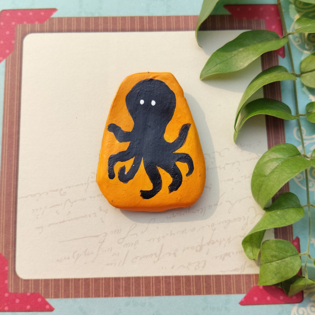 Hand-crafted magnet with black octopus design on mustard background, framed with decorative elements. - Sustainable Home Decor
