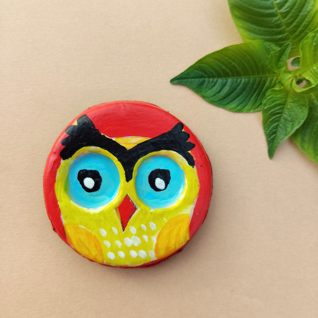 Colorful owl-shaped artistic magnet on a beige background with green leaves - Sustainable Home Decor