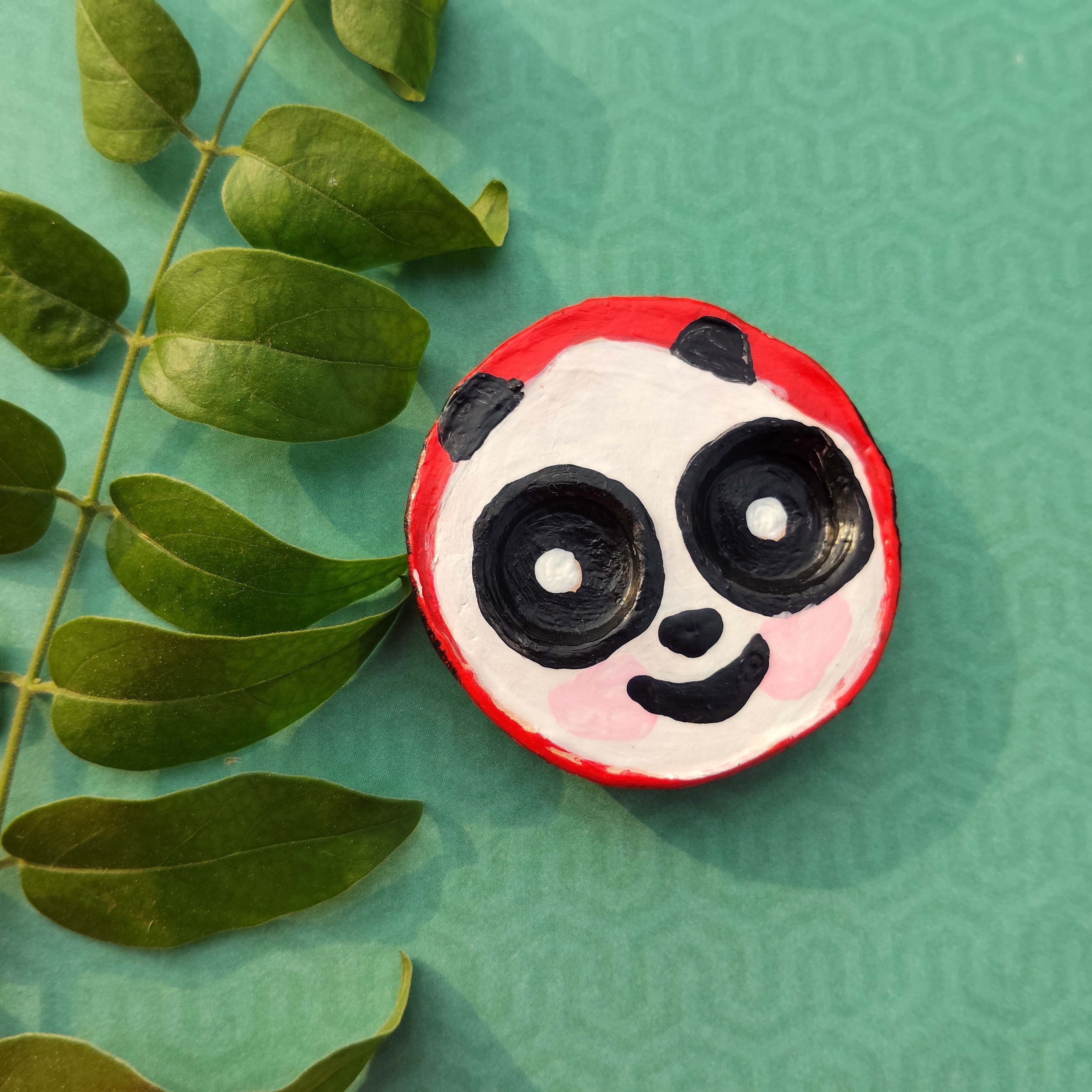 Round hand-crafted magnet with panda design on a green textured background with leaves. - Sustainable Home Decor & Upcycled Glass