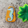 Painted seahorse on a hand-crafted sustainable material with a green leaf