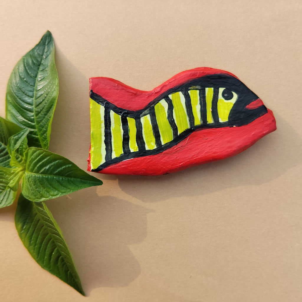 Decorative free hand hand-crafted magnet with snake design next to a green leaf on a beige background - Sustainable Home Decor